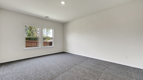 an empty bedroom with gray carpet and white walls