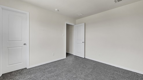 an empty bedroom with gray carpet and white walls