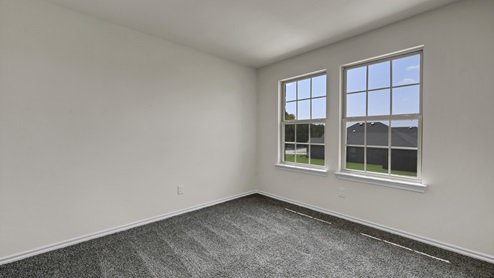 an empty bedroom with gray carpet and white walls