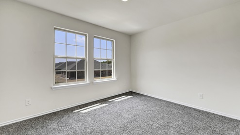 an empty bedroom with gray carpet and white walls