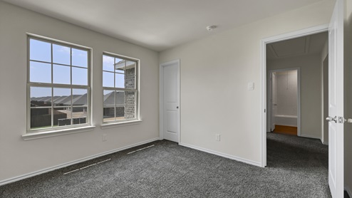 an empty bedroom with gray carpet and white walls