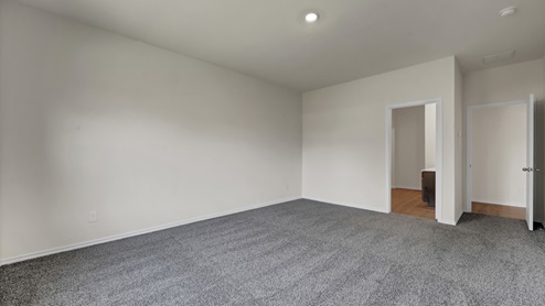 an empty bedroom with gray carpet and white walls