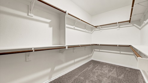 a walk in closet with racks for hanging clothes