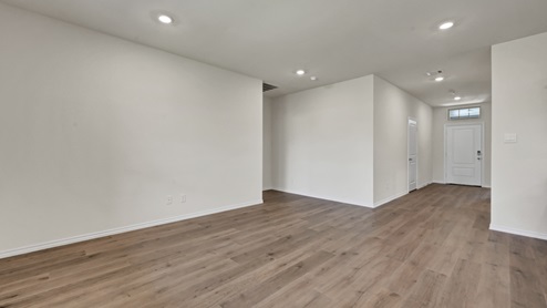 an open living area with wood floors and white walls