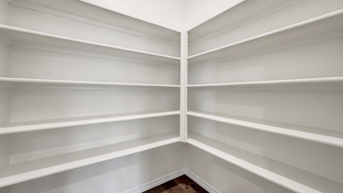 a pantry with white built in cabinets