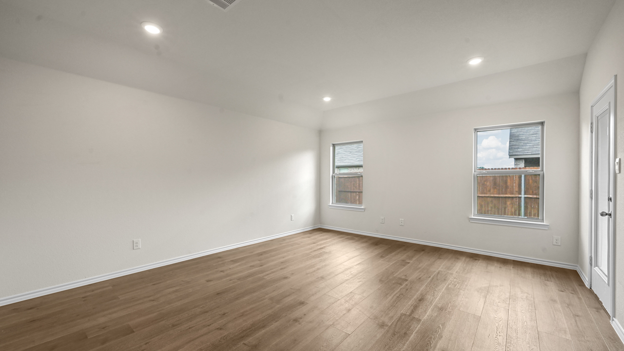 an open living area with white walls and wood floors