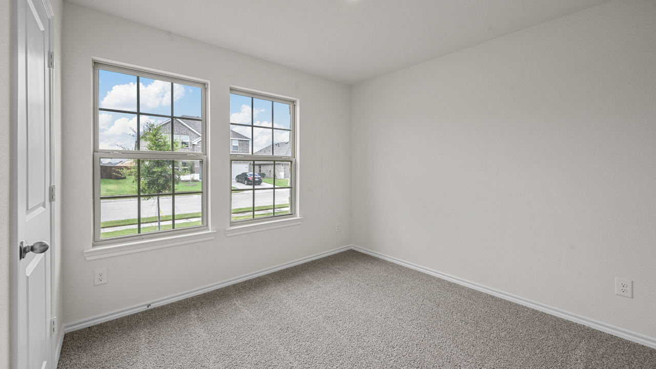an empty bedroom with gray carpet and white walls