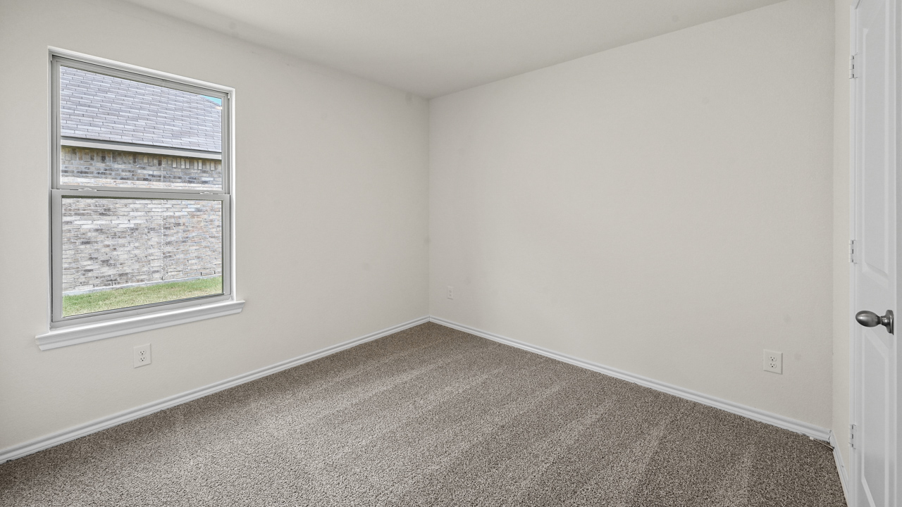 an empty bedroom with gray carpet and white walls