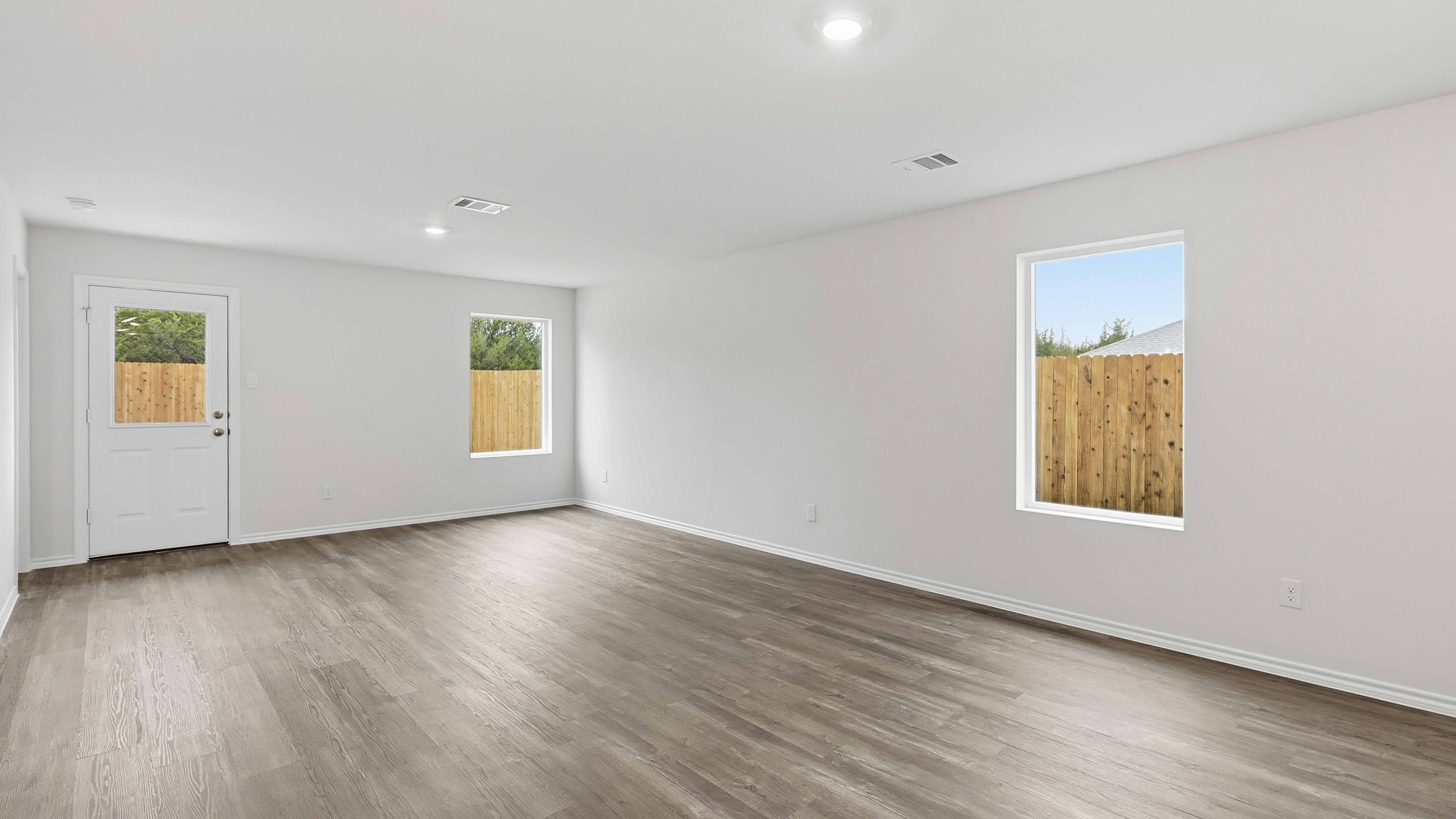 open concept living area with hardwood floors and large windows providing natural light