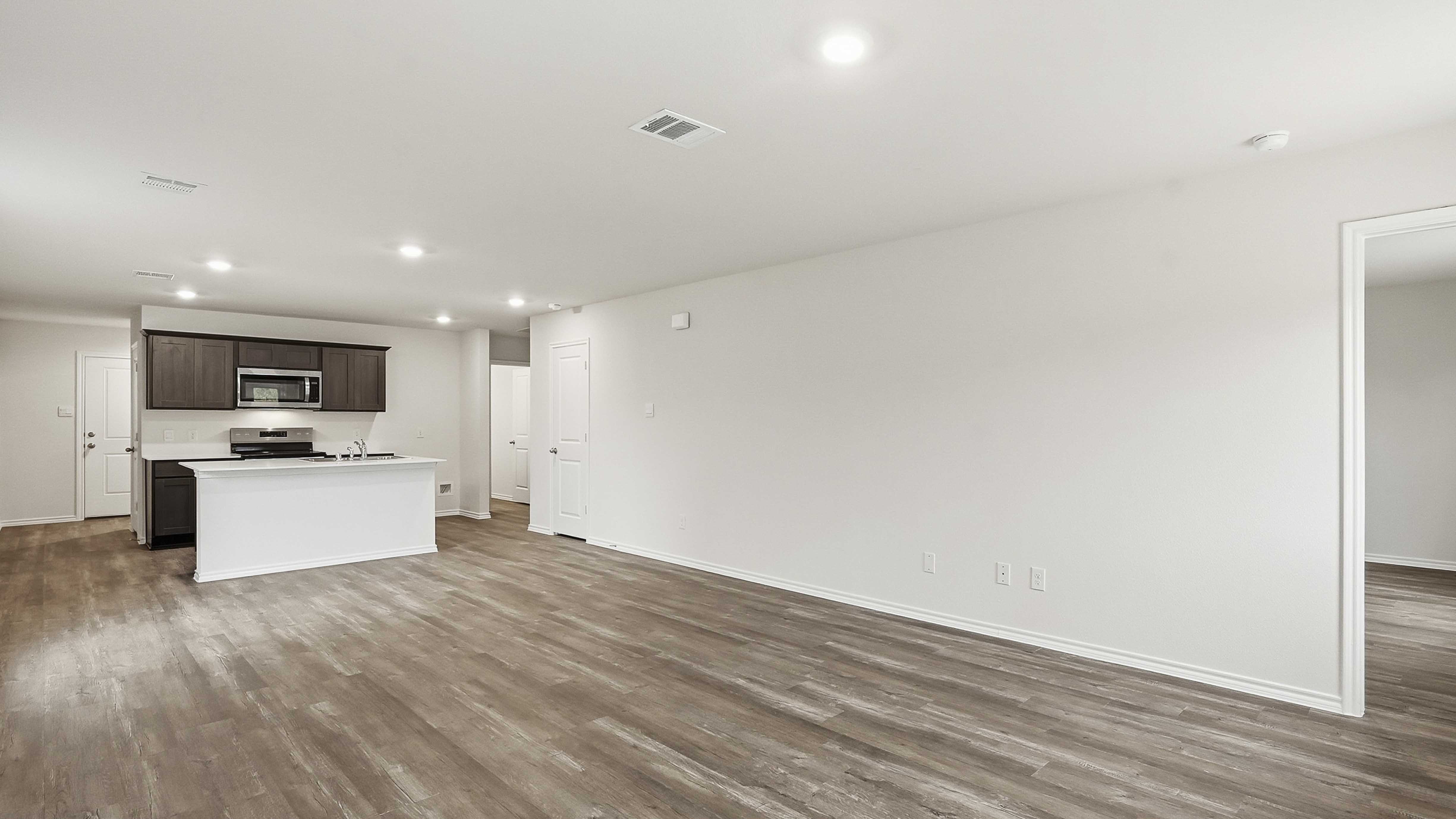 open concept living area with hardwood floors and large windows providing natural light