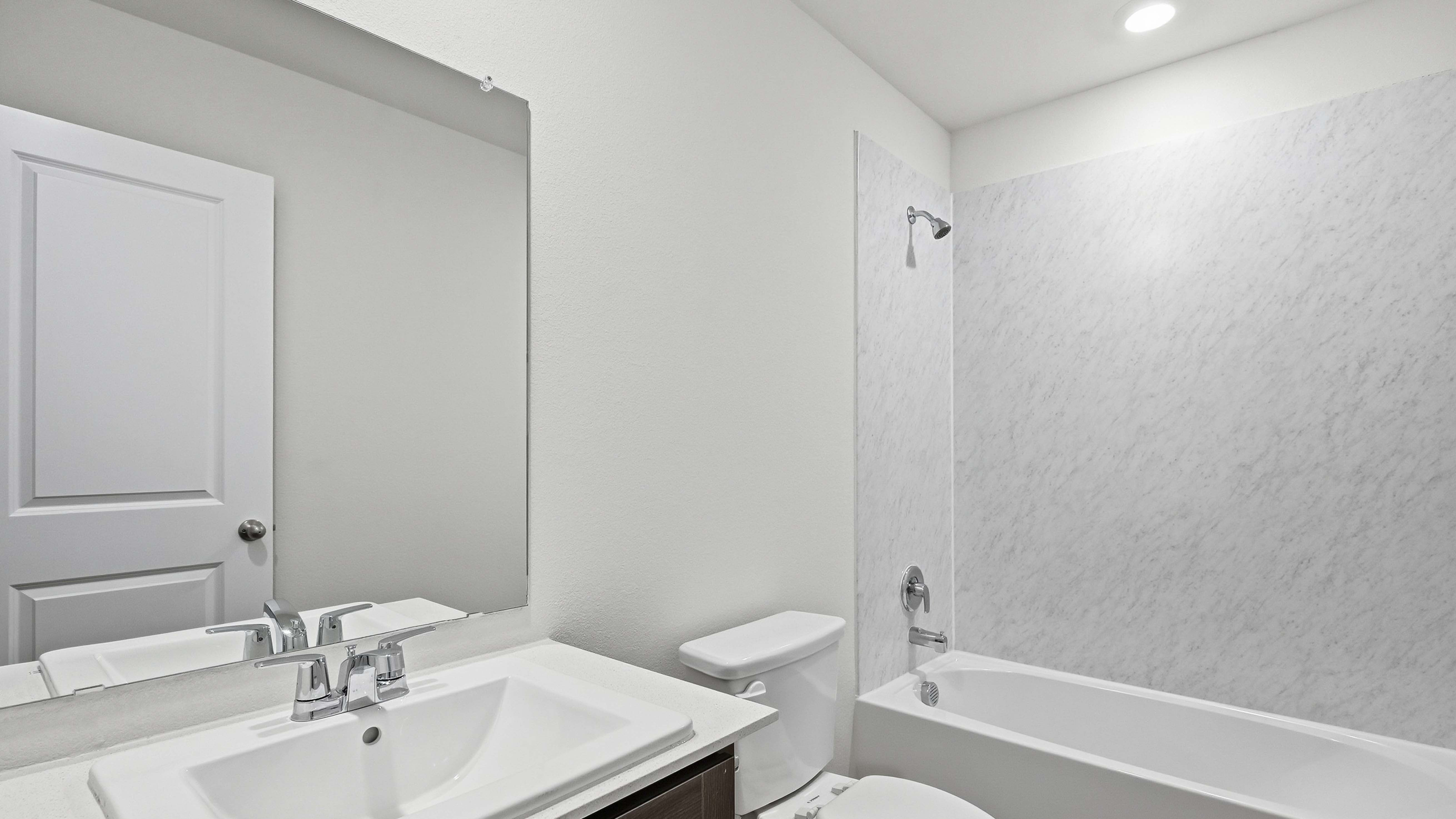 secondary bathroom with hardwood floors and dark cabinets