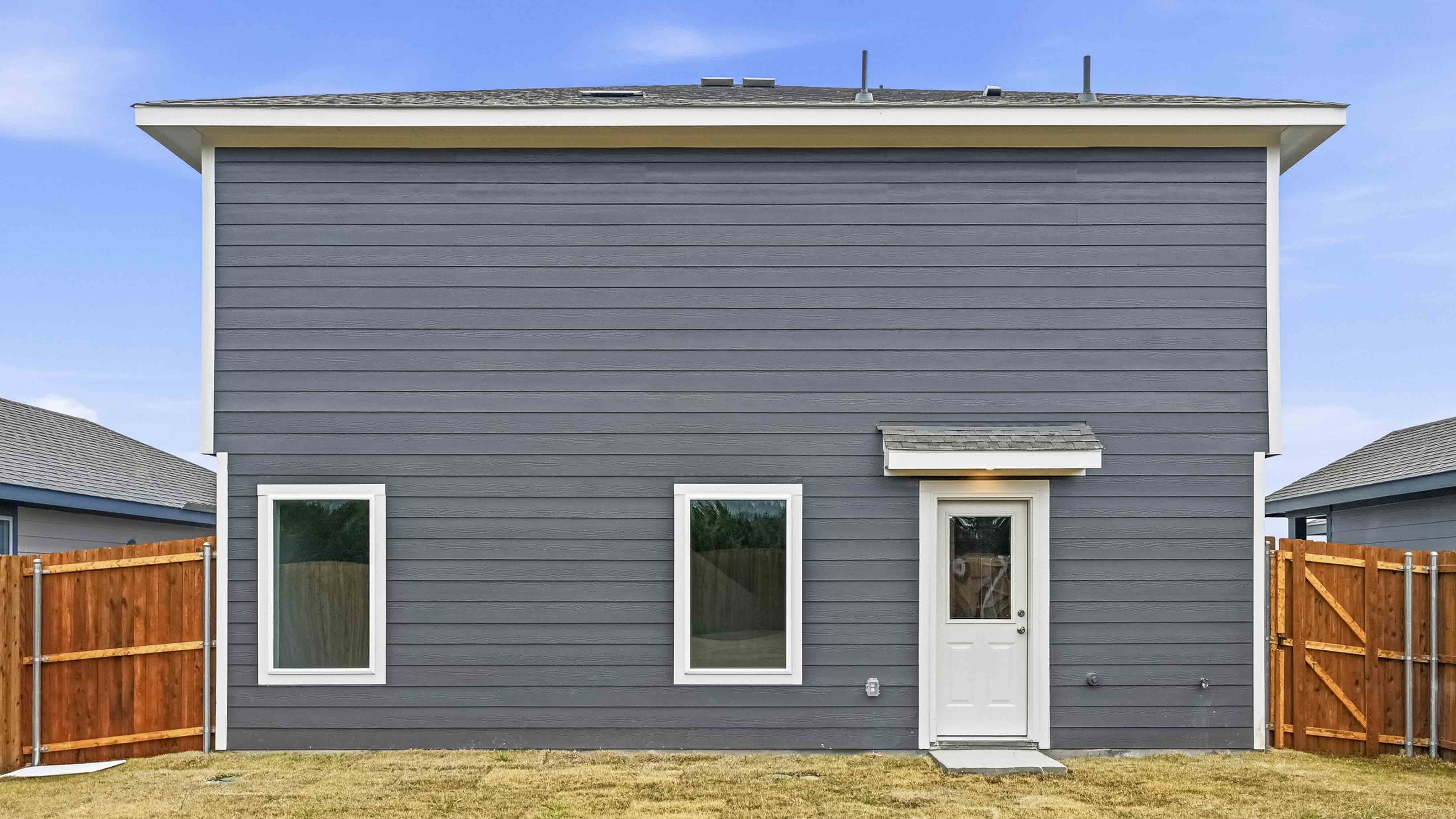 backyard of two story home with siding exterior