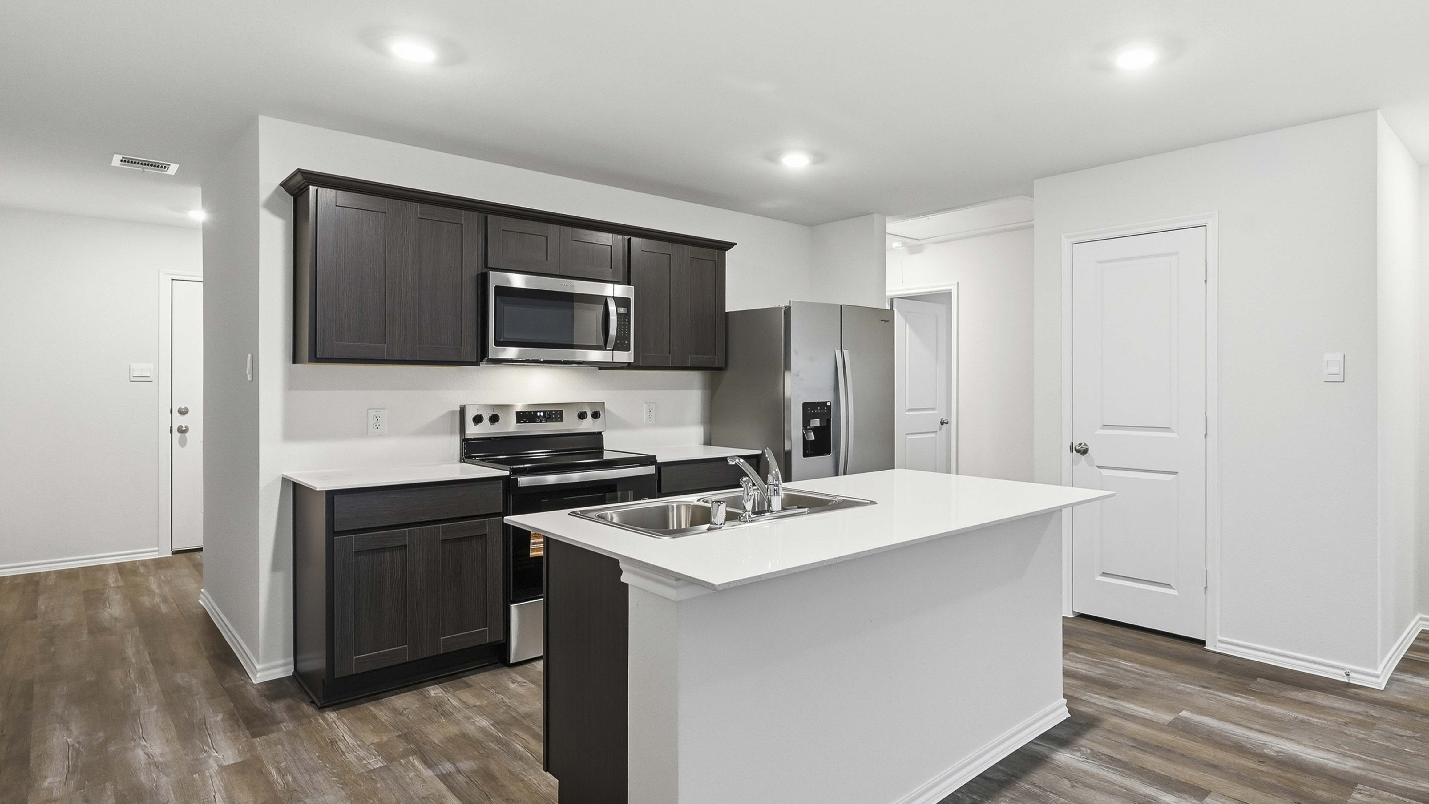 kitchen area with hardwood floors white counters and dark cabinets