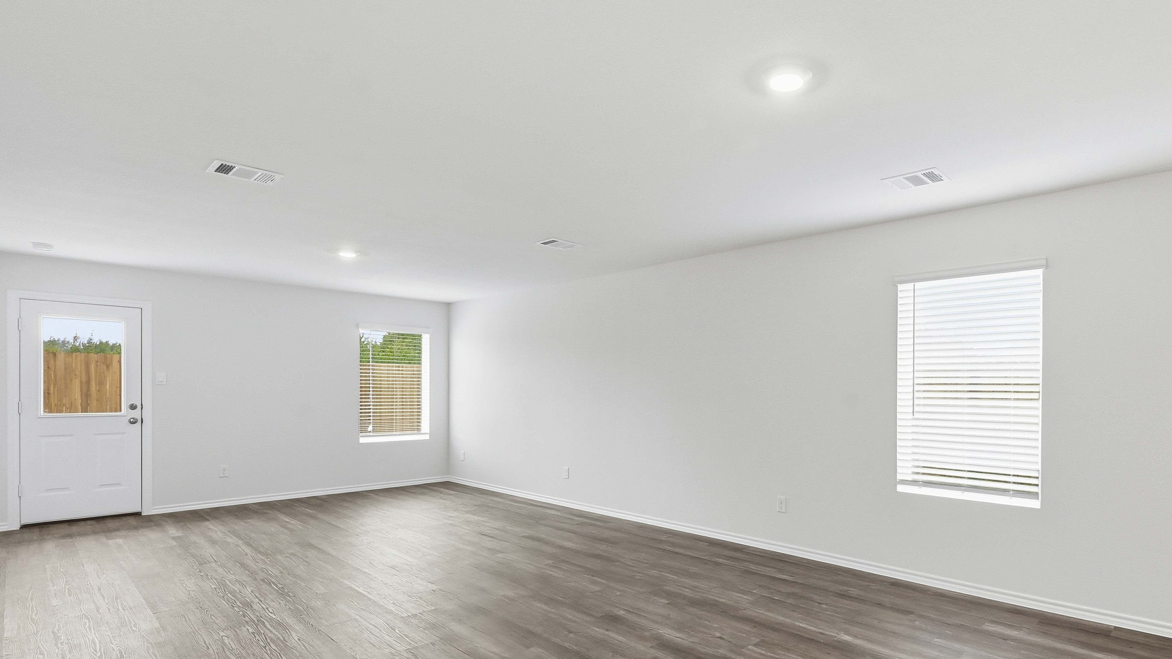 open concept living area with hardwood floors and large windows providing natural light