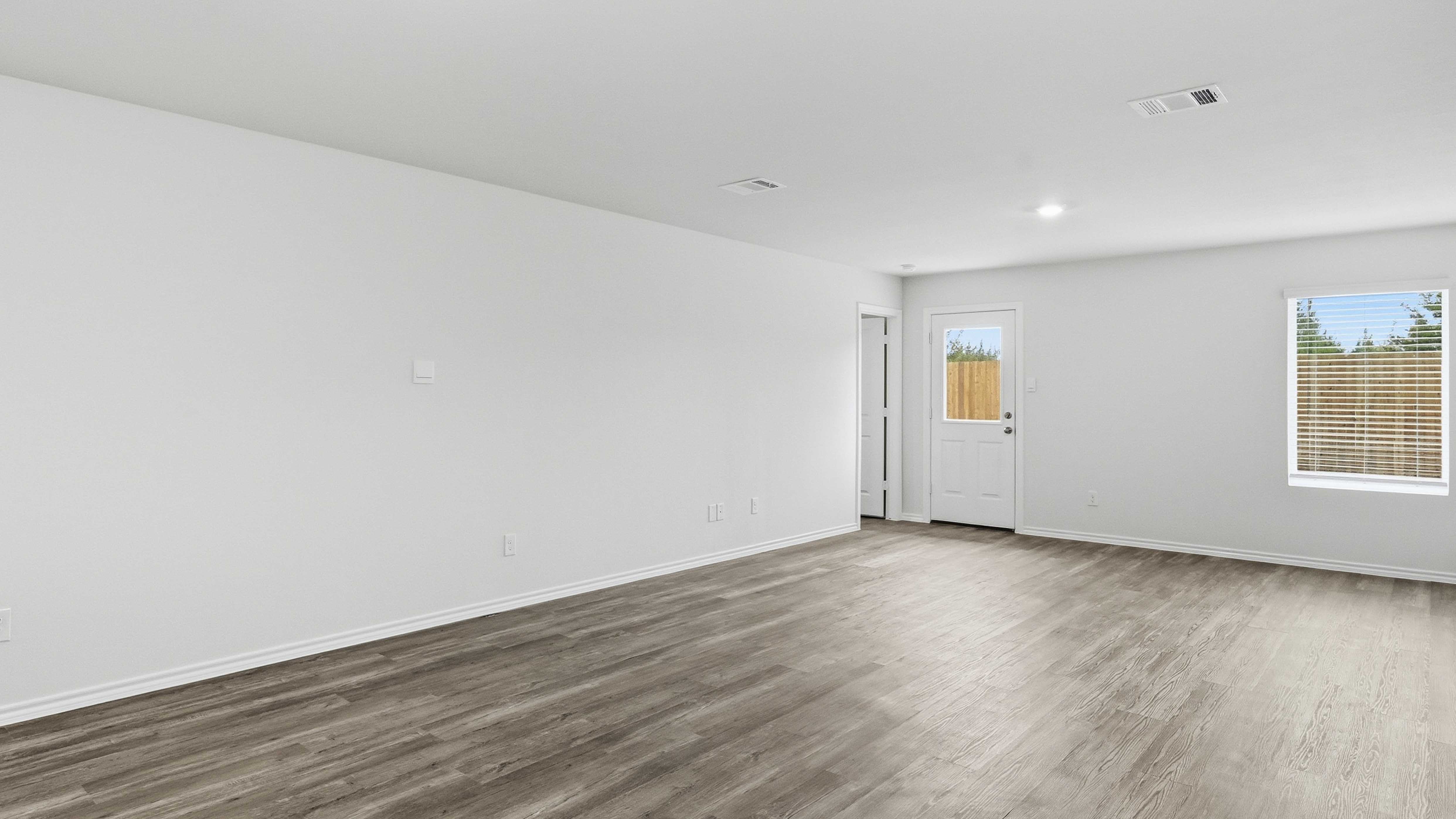 open concept living area with hardwood floors and large windows providing natural light