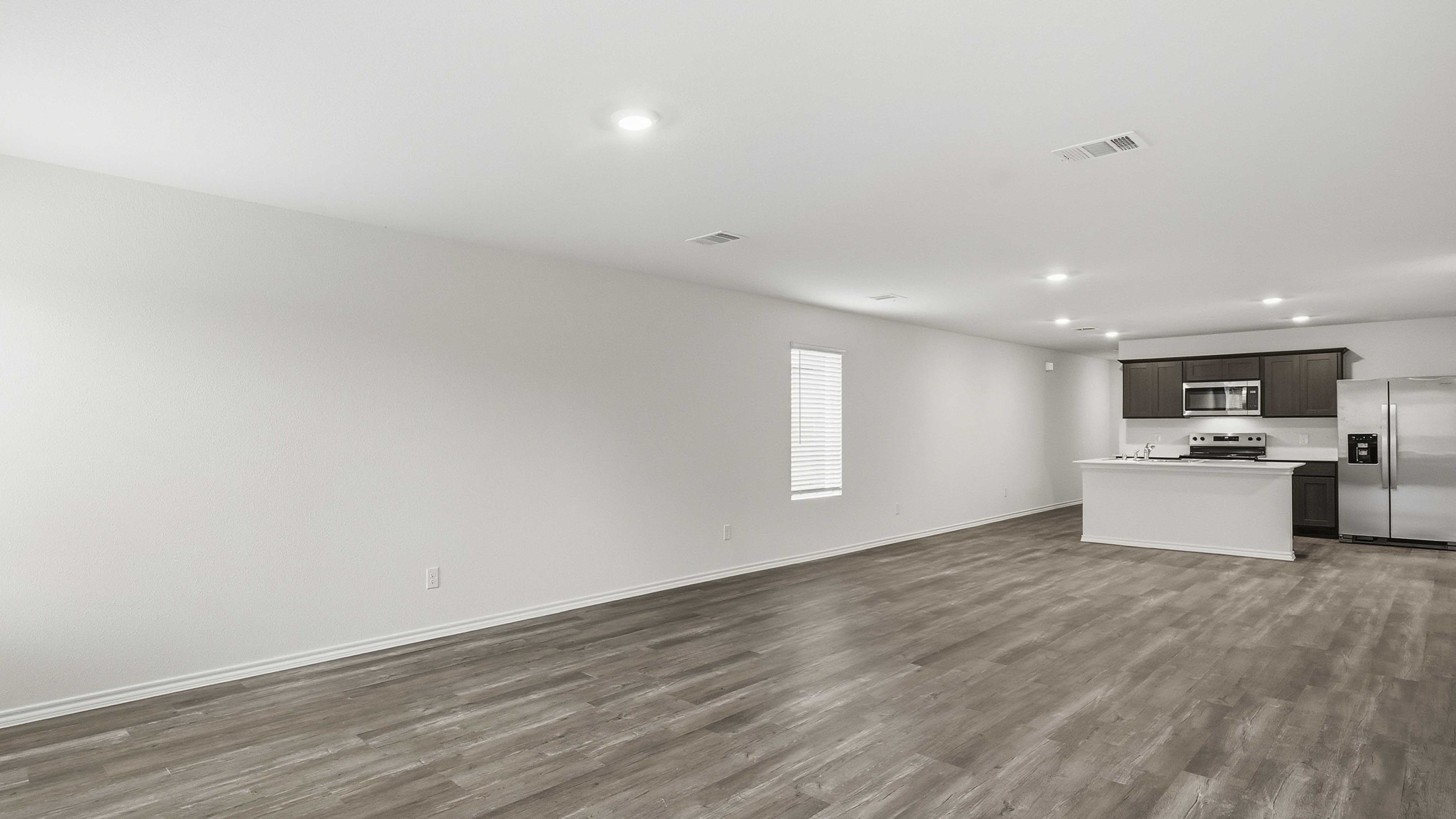 open concept living area with hardwood floors and large windows providing natural light