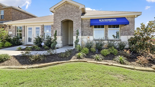 Single story model home with blue DR. Horton awning and beautiful landscaping