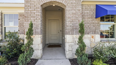 Close up of Single story model home with blue DR. Horton awning and beautiful landscaping