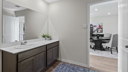 Primary bathroom with white counter vanity and brown cabinets