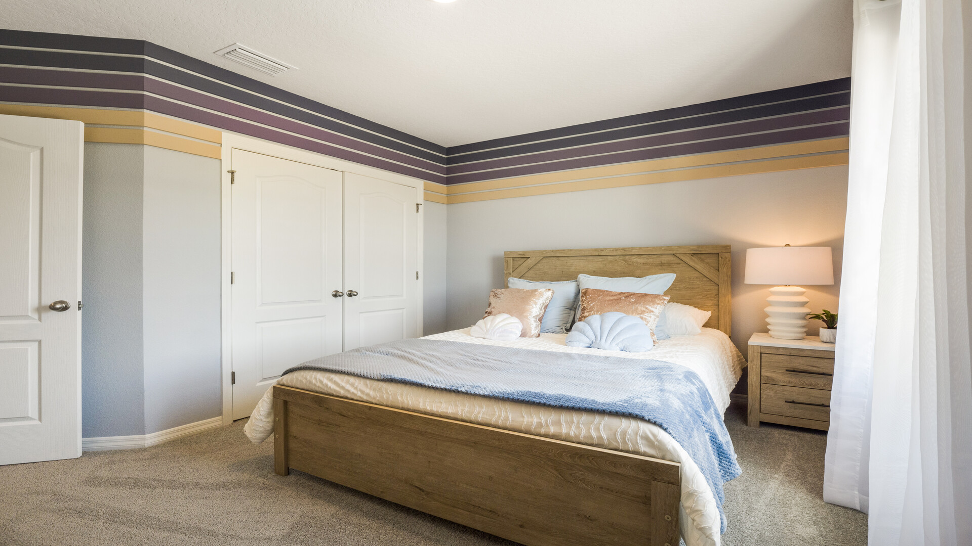 Guest bedroom with bed, nightstands and a roomy closet for storage.