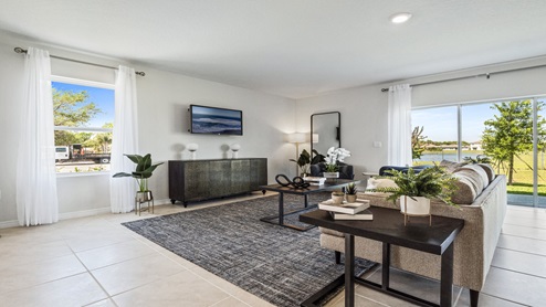 Open concept living area with couch seating and access to the backyard thru slider door.
