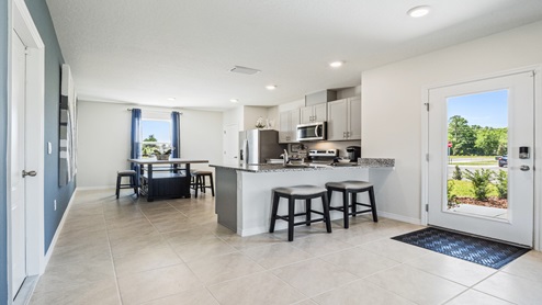 Kitchen with tall cabinetry, appliances, walk in pantry and tile flooring.
