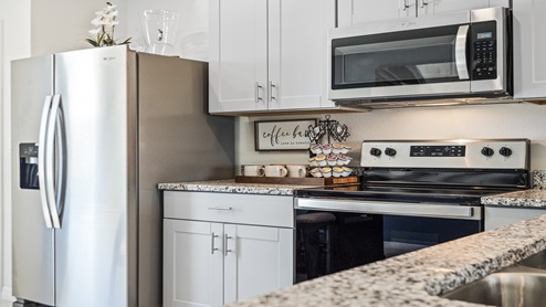 Kitchen with granite counters and stainless-steel appliances.