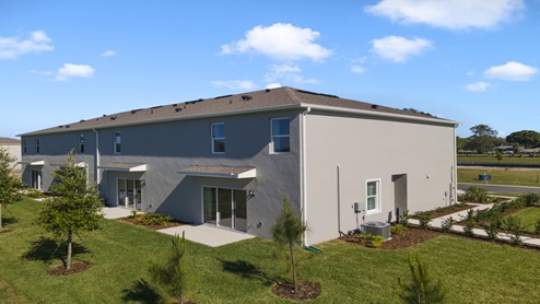 Two-story townhome with stucco exterior and windows.