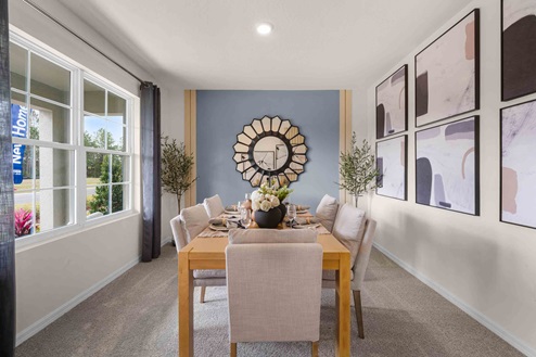 Dining room adjacent to the kitchen with table, chairs and tile flooring.
