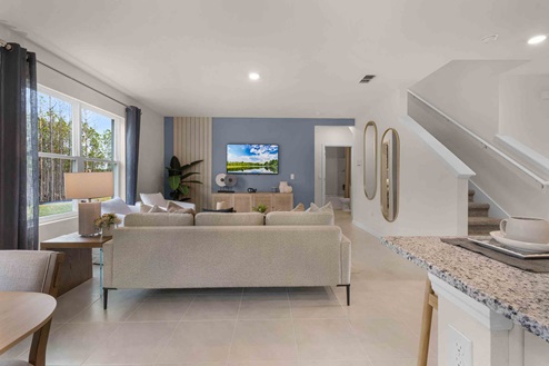 Open concept living area with couch seating and access to the backyard thru slider door.