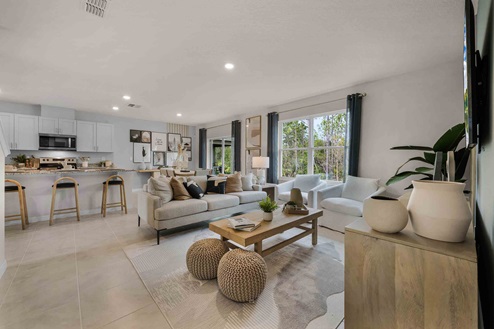 Open concept living area with couch seating and access to the backyard thru slider door.