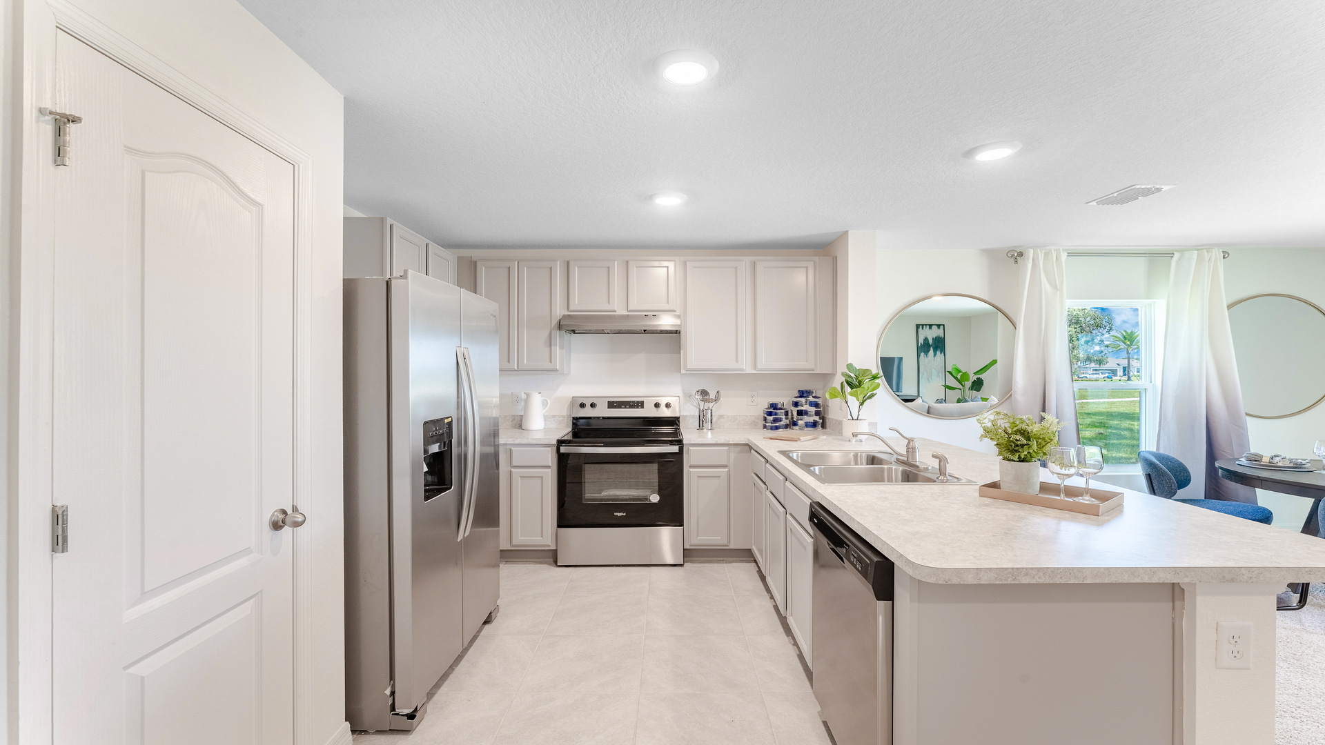 Kitchen with island seating, granite counters, spacious pantry and stainless-steel appliances.