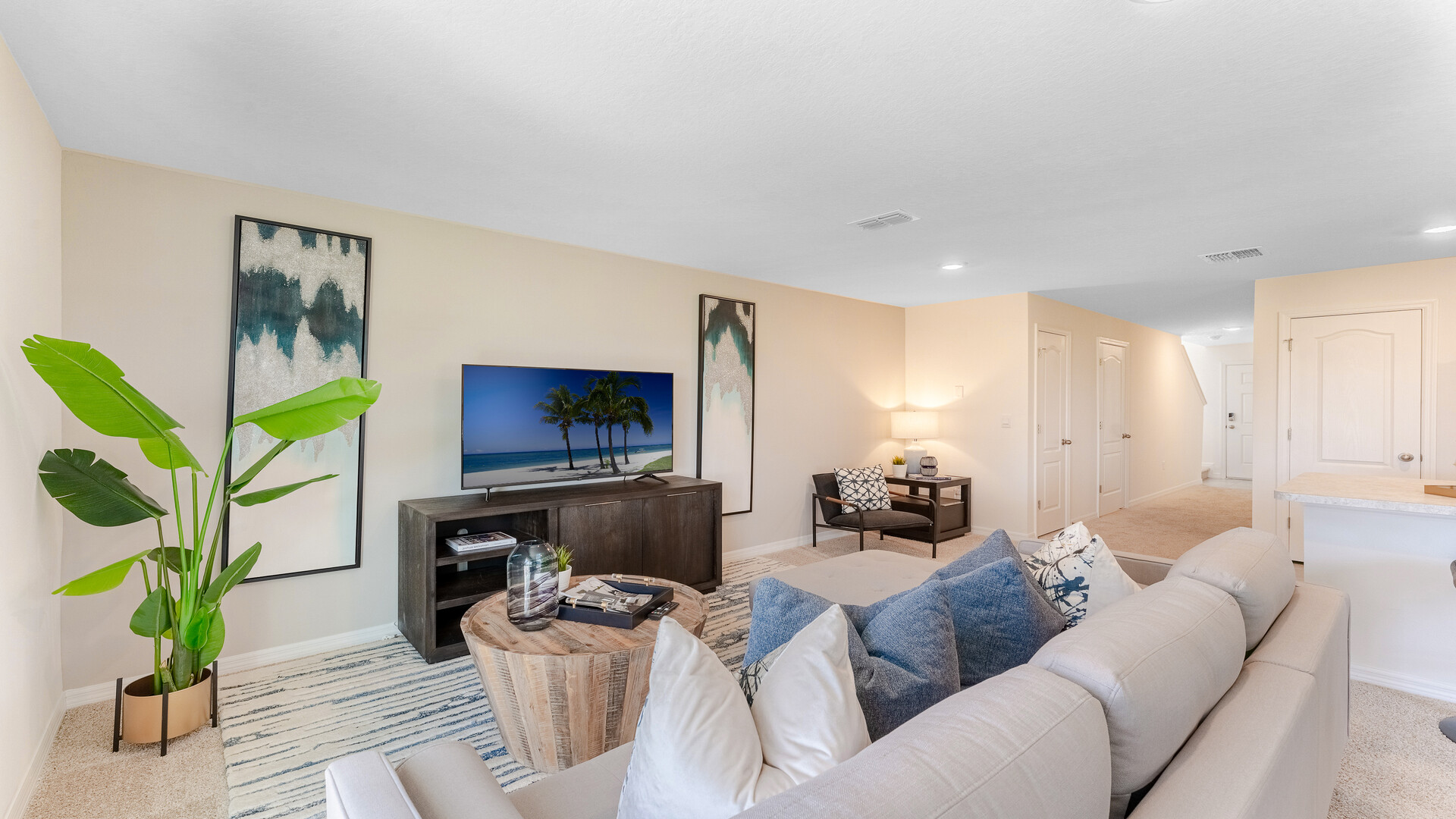 Open concept living area with couch seating and access to the backyard thru slider door.