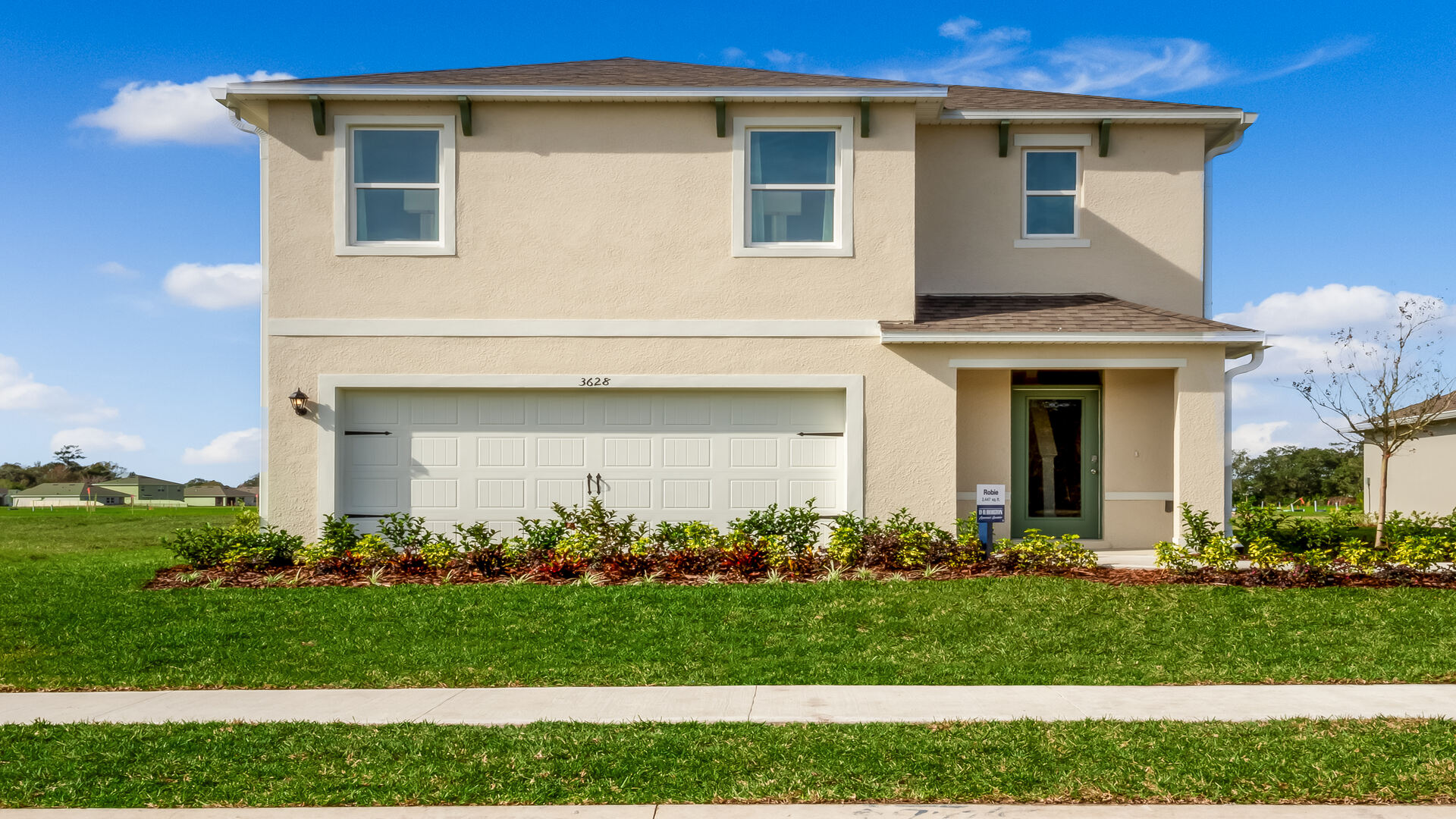 Two-story new home with siding, covered porch and 2 car garage.