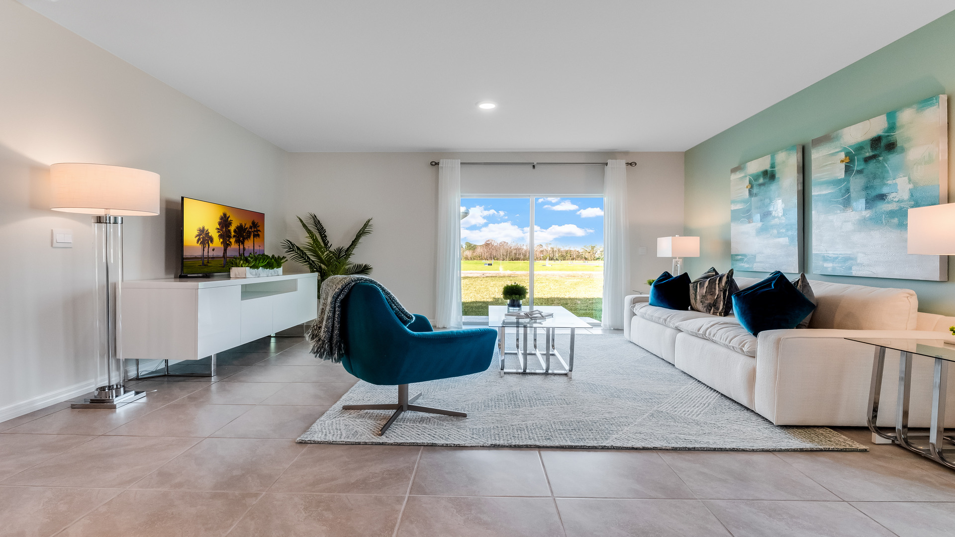 Open concept living area with couch seating and access to the backyard thru slider door.