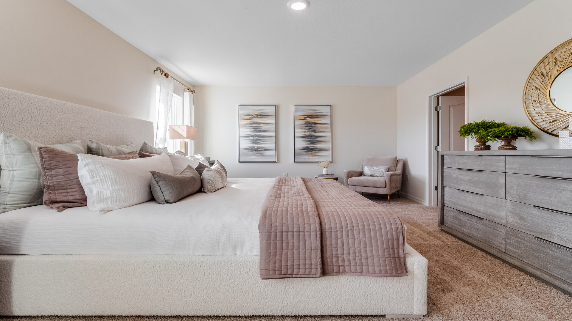 Spacious primary bedroom with king size bed, carpet flooring, natural lighting and a walk in closet.