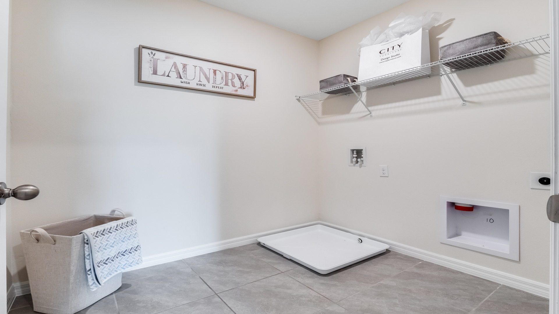 Laundry room with tile flooring, a window and wire shelving on the wall for storage