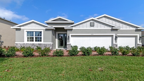 Single story new home with siding, covered porch and 3 car garage.