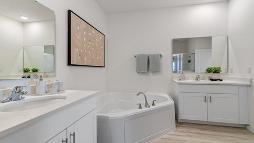 Modern bathroom with double vanity, large wall mirror, cabinets and granite countertops along with walk-in shower