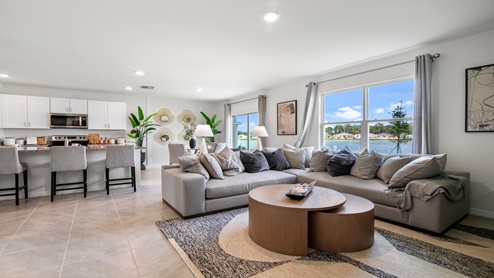Open concept living area with couch seating and access to the backyard thru slider door.
