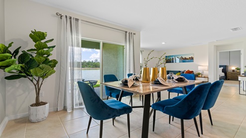 Dining room adjacent to the kitchen with table, chairs and tile flooring.
