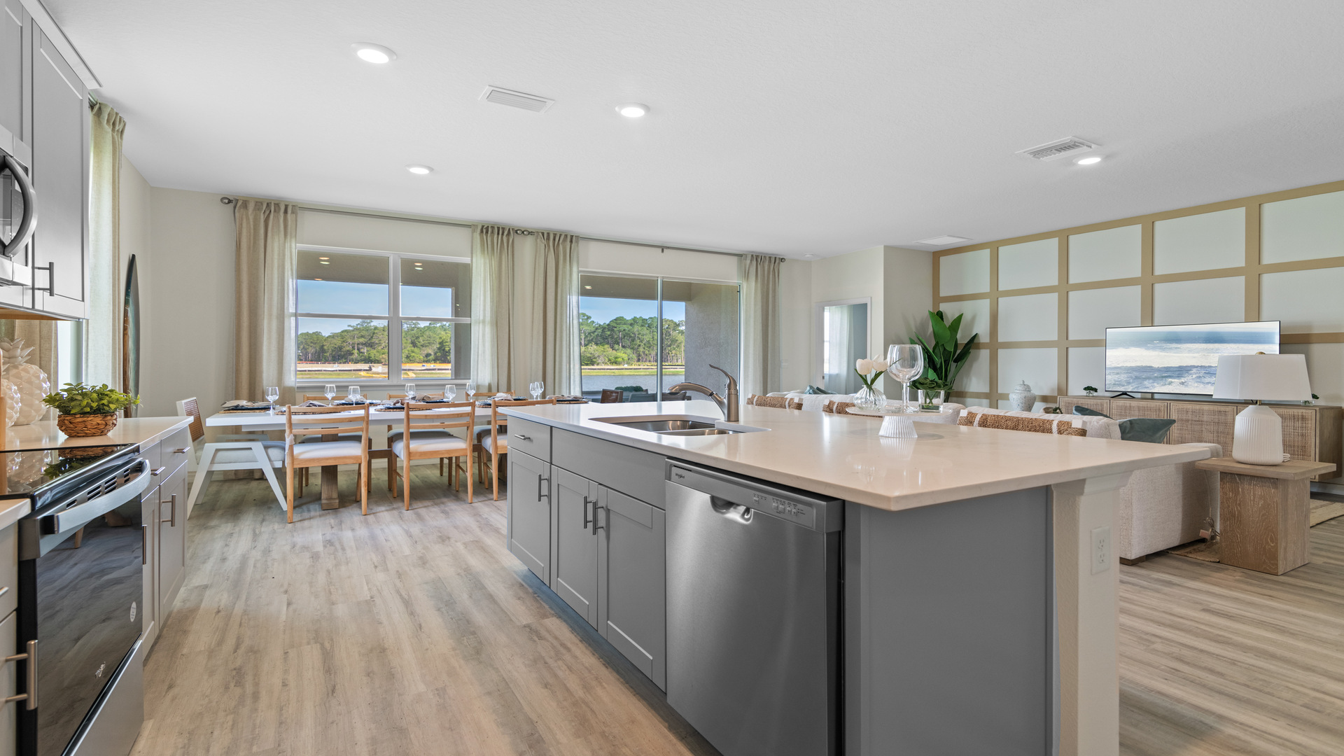 Kitchen with island seating, granite counters, spacous pantry and stainless steel appliances.
