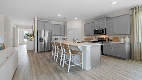 Kitchen with island seating, granite counters, spacious pantry and enough room for a large refrigerator .