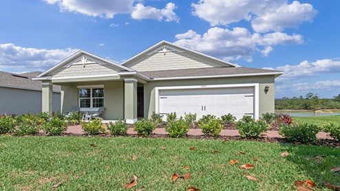 Single story new home with siding, covered porch and 2 car garage.