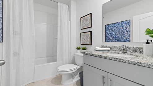 Modern bathroom with Single vanity, large wall mirror, cabinets and granite countertops.