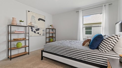 Spare bedroom for guests, with bed, dresser, and ample closet storage.