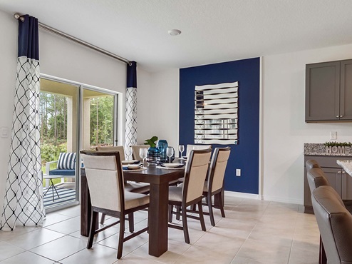 Dining room adjacent to the kitchen with table, chairs and tile flooring.
