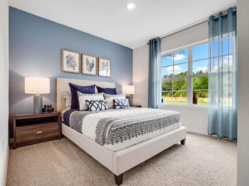Guest bedroom with bed, nighstands and natural lighting.