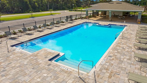 Sunny day at the community swimming pool with lounge seating.