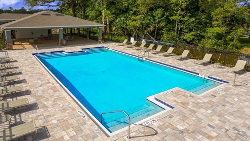 Sunny day at the community swimming pool with lounge seating.